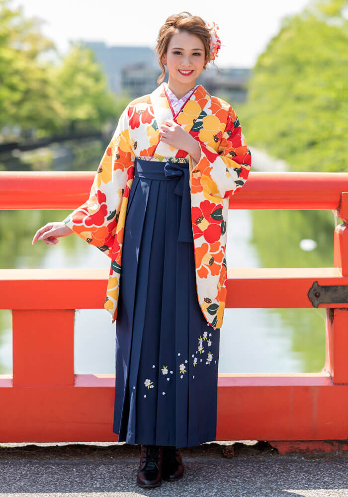 華やかなオレンジの着物を、クールな紺の袴で締めたオシャレなレンタル袴コーディネート。